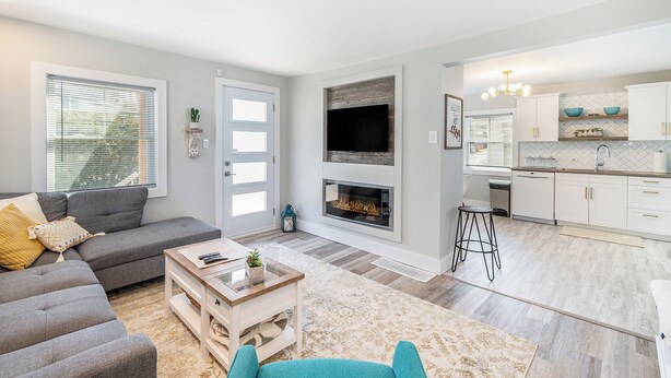 Un salon moderne avec un canapé gris, une table basse en bois et une cheminée.