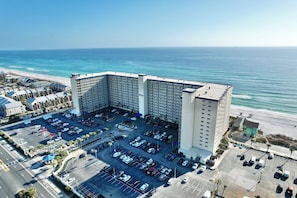 Un grande hotel con parcheggio e vista sull'oceano.