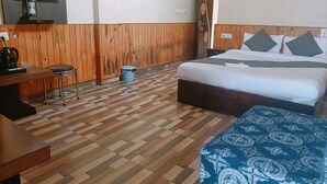 Une chambre d’hôtel équipée d’un lit, d’un bureau, d’une chaise, d’une machine à café et d’une poubelle.