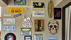 Una pared con varios pegatinas de viajes y una silla azul.