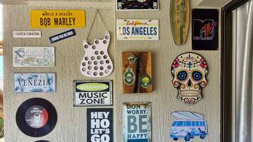A wall with various travel-themed stickers and a blue chair.