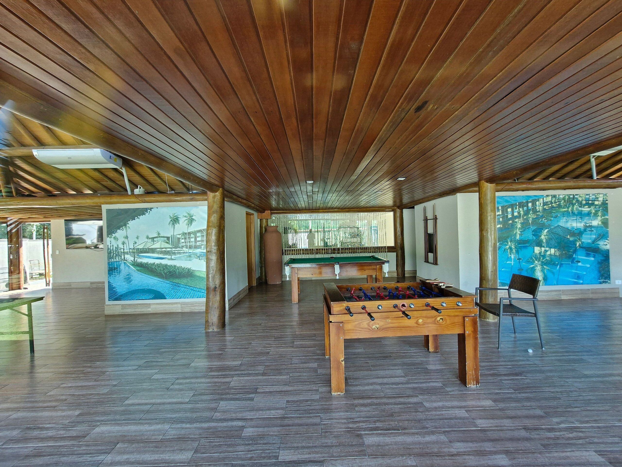 A spacious indoor area with a pool table, foosball table, and a billiards table.