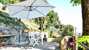 An outdoor patio with a table and chairs, a white umbrella, and potted plants. - Villa Antonella, app. Victory (Tavernerio)