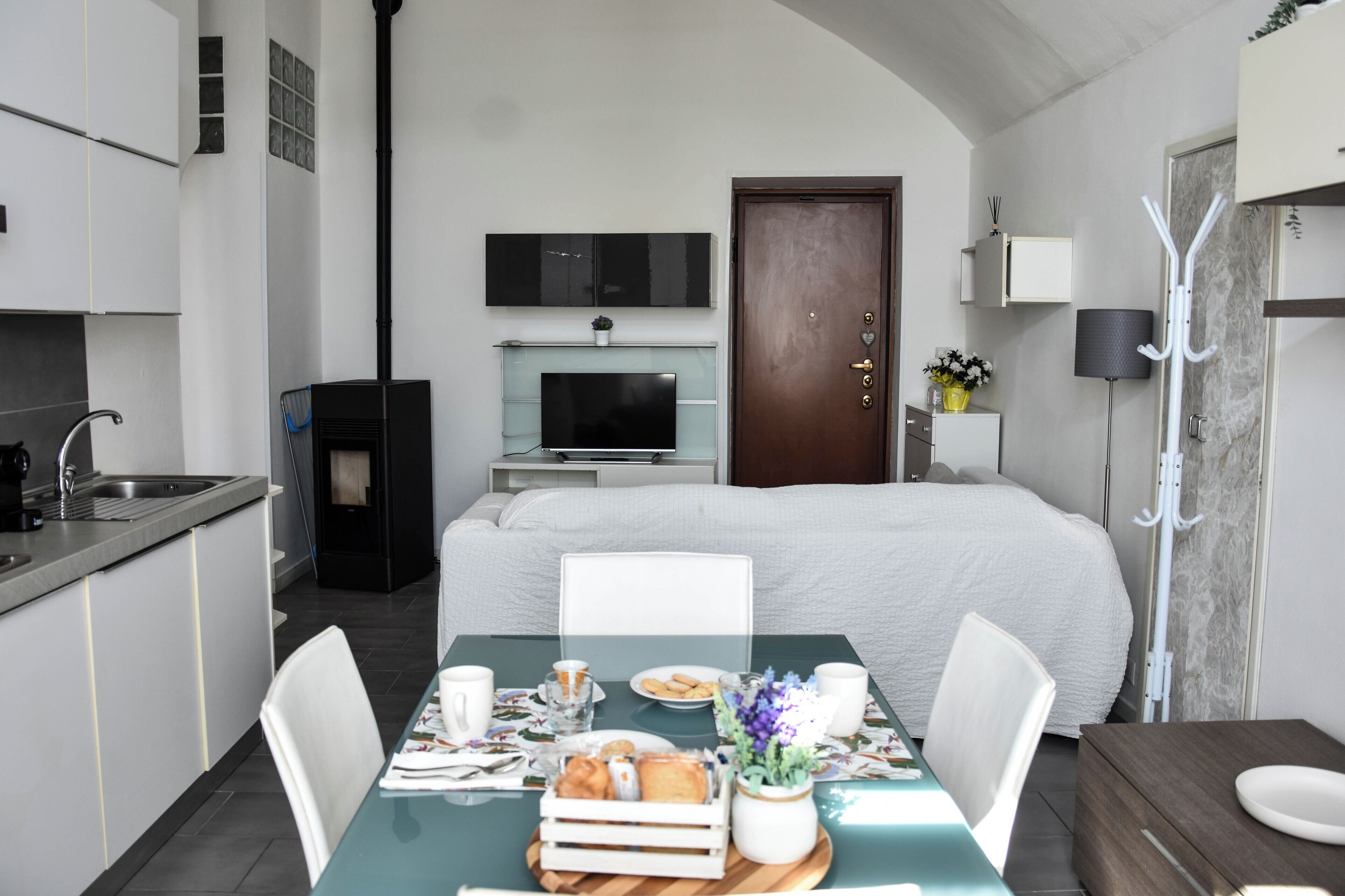 Une chambre d’hôtel moderne dotée d’un coin repas, d’une kitchenette et d’un grand lit.
