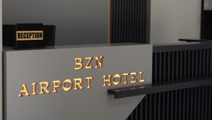 A reception desk with 'BZN AIRPORT HOTEL' signage and a 'RECEPTION' sign above it. - BZN AİRPORT HOTEL (Arnavutköy)