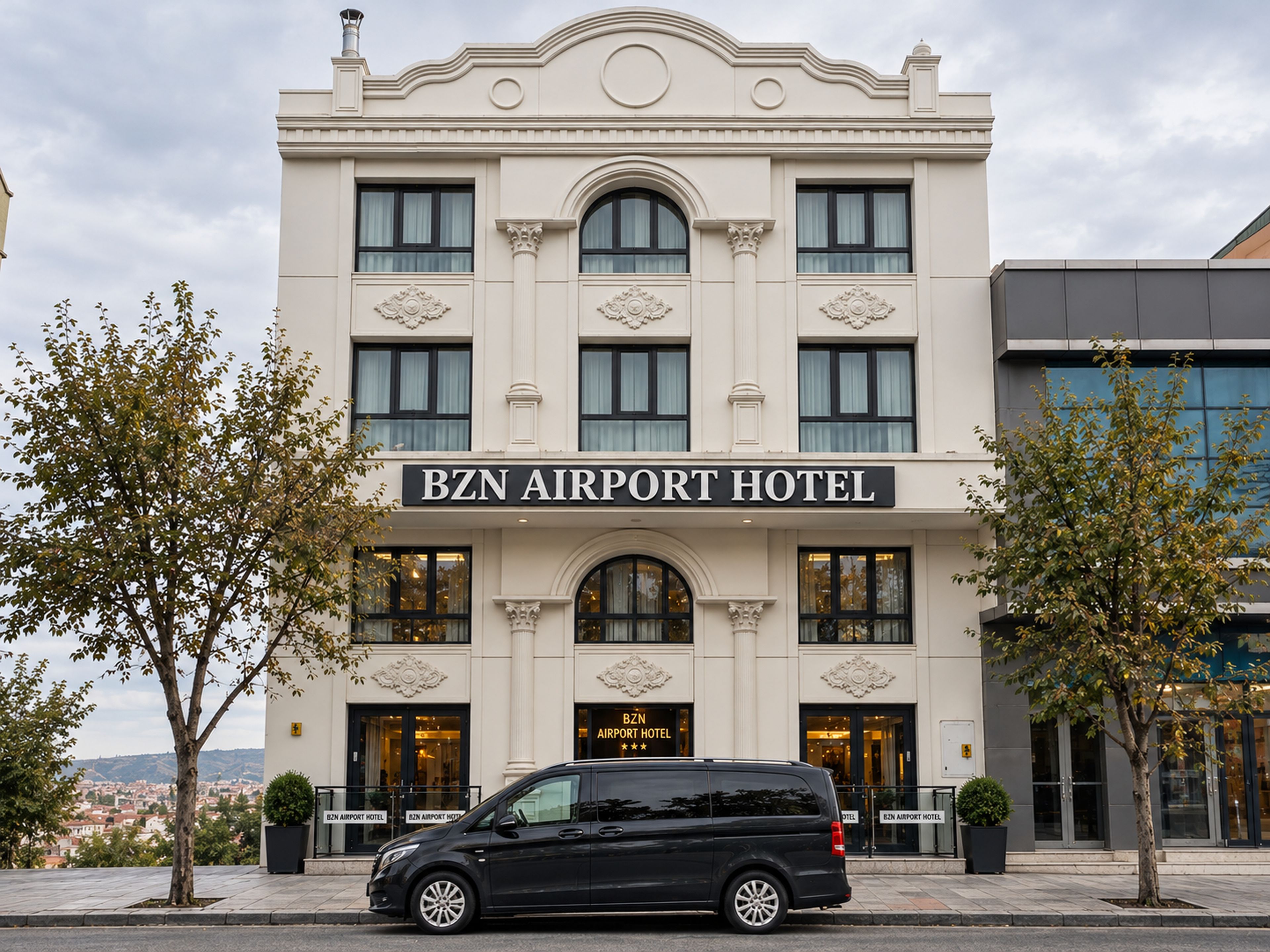 Un bâtiment sur lequel on peut lire l’inscription « HÔTEL DE L’AÉROPORT BZN », avec un fourgon noir garé devant.