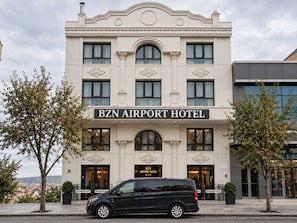 A building with a sign reading 'BZN AIRPORT HOTEL' with a black van parked in front. - BZN AİRPORT HOTEL (Arnavutköy)