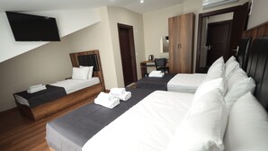 A hotel room with two beds, a desk, a chair, a TV, and a wardrobe. - BZN AİRPORT HOTEL (Arnavutköy)