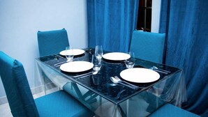 A dining table with four chairs, set for four people.