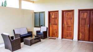A room with a sofa set, a coffee table, and two wooden doors.
