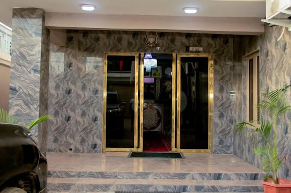 A reception area with marble walls and a glass door entrance. - Piston Guest Inn (Kano)