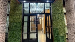 The entrance of the FAST10 City Hotel with a modern design, featuring a metal and glass facade, and a green wall on either side. - Fast 10 City Hotel (Porto Alegre)