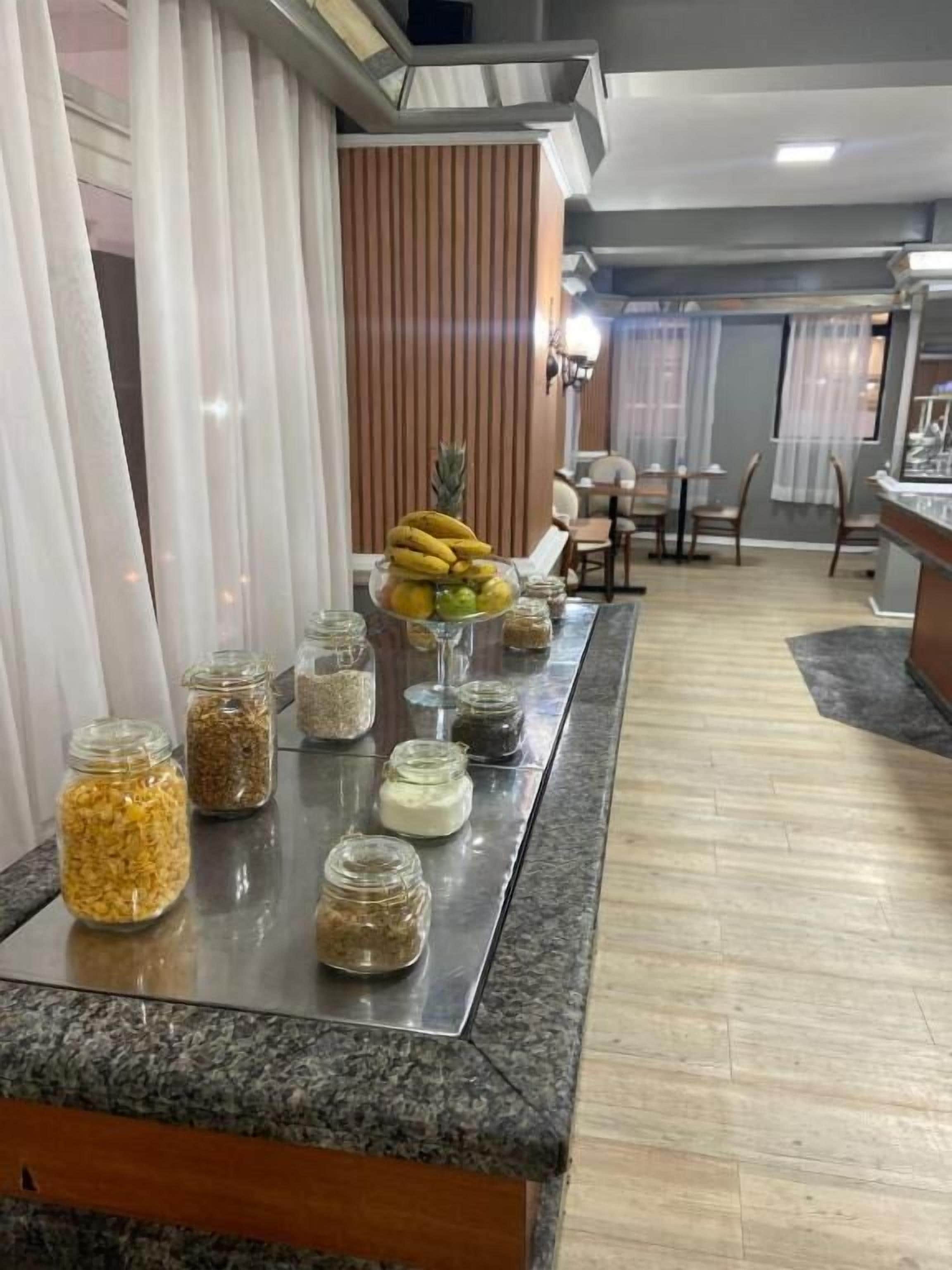 A buffet area with a variety of food items displayed in jars and a fruit bowl.