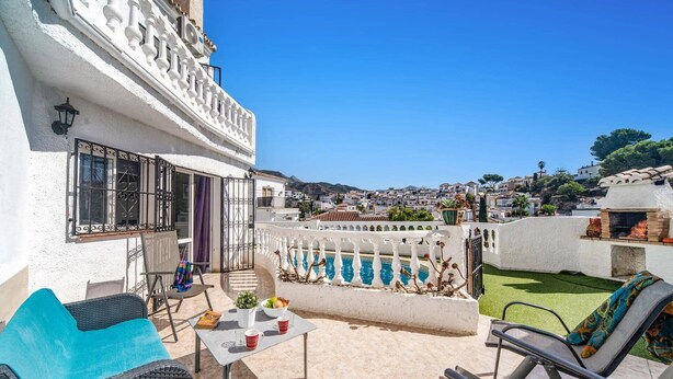 Eine Dachterrasse mit Sitzgelegenheiten im Freien, einem Pool und Blick auf die umliegende Stadt.