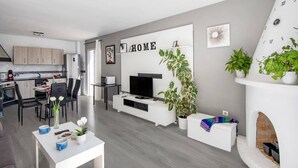 Ein modernes Wohnzimmer mit Kamin, Essbereich und Küche.