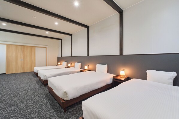 A hotel room with four single beds, wooden headboards, and bedside lamps. - Aoyagi Stay (Hakodate)