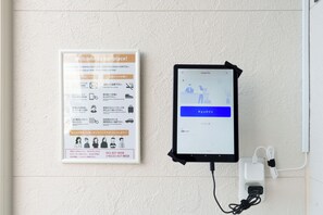 A welcome sign with instructions and a tablet displaying a check-in interface. - Aoyagi  Stay (Hakodate)