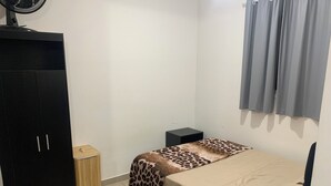 A bedroom with a bed, a wardrobe, a small bedside table, and a ceiling fan. - Studio Space SM Araguaia (Vila Galvão Guarulhos)