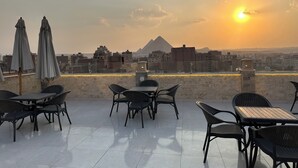 Une terrasse sur le toit, dotée d’un espace extérieur aménagé et offrant une vue sur le paysage urbain et une montagne.