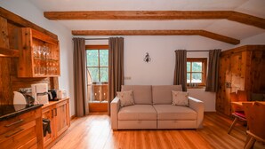 A cozy living room with a sofa, wooden cabinets, and a dining area.