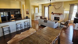 Una cocina moderna con una isla central, una sala de estar con chimenea y un comedor de diseño exclusivo.