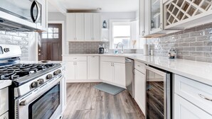 Una cocina moderna con armarios blancos, estufa de acero inoxidable y lavavajillas.