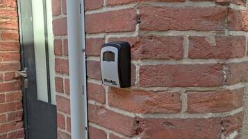 A brick wall with a door and a security device labeled "Master Lock".