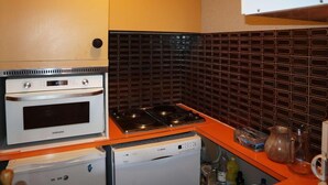 A compact kitchen with a white oven, a gas stove, and a built-in dishwasher. - Ski-in/ski-out & foot of the slopes, 2nd floor, balcony, tv, ski locker, 32m², Les Orres (Les Orres)