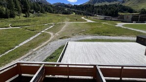 A view from a covered deck with a wooden floor, overlooking a mountainous landscape with a clear sky. - Ski-in/ski-out & foot of the slopes, 2nd floor, view ski slopes, balcony, tv, 20m², La Plagne (La Plagne)
