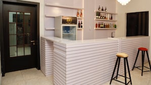 A modern bar area with a counter, stools, and shelves of bottles. - Executive Luxury Room - Sleeps 2 - Pool - Gym (Lekki)