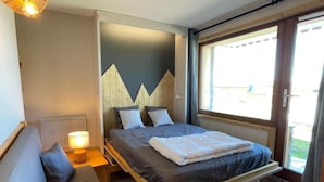 Ein Schlafzimmer mit einem Bett, Nachttischen, einer Lampe und einem Fenster.