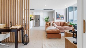 Un salon moderne avec un canapé, une table à manger et une cuisine en arrière-plan.