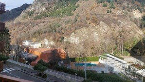 A view of a mountainous landscape with a building featuring a swimming pool and a covered outdoor area. - 100m from resort center, 3rd floor, balcony, tv, ski locker, 30m², Brides Les Bains (Brides-les-Bains)
