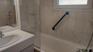 A bathroom with a glass shower enclosure, a white sink, and a window above the bathtub. - 100m from resort center, 3rd floor, balcony, tv, ski locker, 30m², Brides Les Bains (Brides-les-Bains)