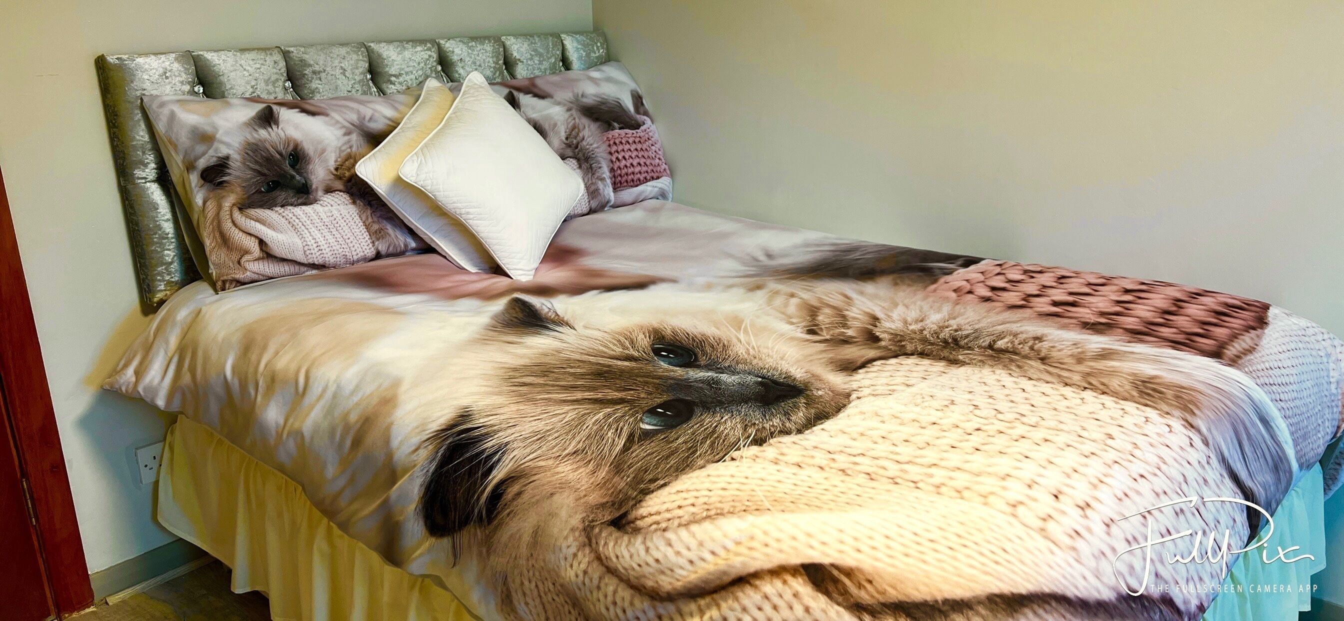 Un lit avec une tête de lit, des oreillers et une couverture.