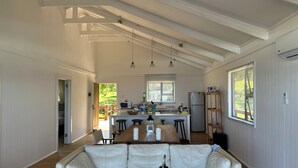 Amplia sala de estar con sofá, mesa de comedor y cocina al fondo.