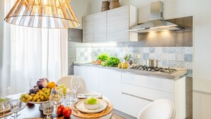 A modern kitchen with a gas stove, white cabinets, and a tiled backsplash. - Contemporary 2 Bedrooms Apartment in Montecarlo (Montecarlo)