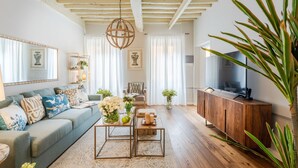 A living room with a sofa, coffee table, TV, and wooden cabinet. - Contemporary 2 Bedrooms Apartment in Montecarlo (Montecarlo)