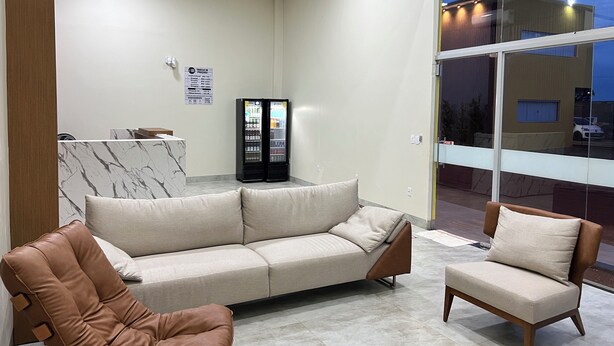 A modern living room with a sofa, two armchairs, and a marble-patterned wall. - Hotel Porto Sollar (Porto Nacional)