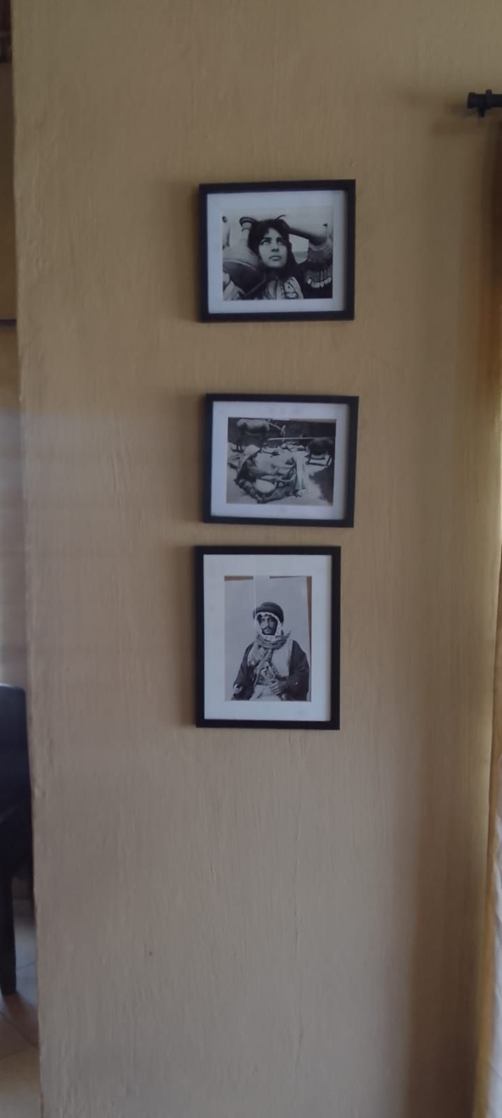 Three framed photographs on a wall.