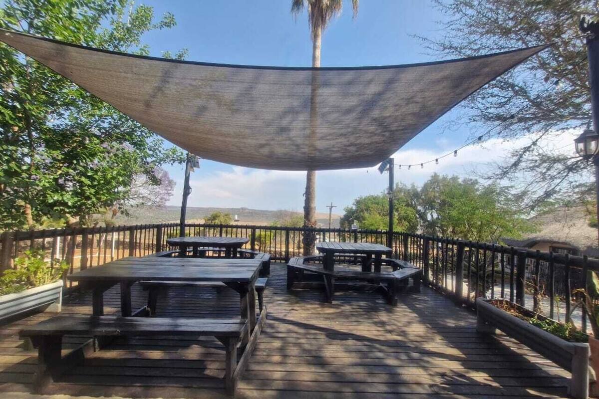 An outdoor patio with picnic tables and a shaded area.
