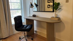 Un espacio de oficina moderno con un escritorio, una silla y una planta en maceta.