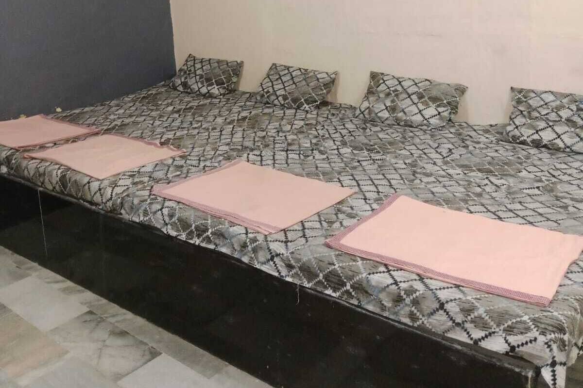 Una habitación con una cama, ventilador de techo y aire acondicionado.