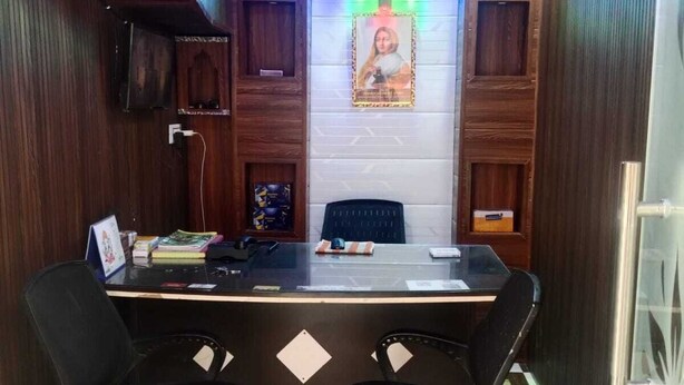 A small office with a desk, two chairs, a framed picture on the wall, and a patterned floor. - HOLKAR SEVA SADAN (Mathura)