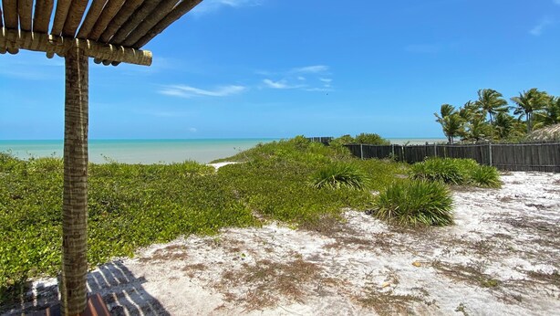 A wooden deck with a view of a beach and ocean. - Aponem Spa Pousada (Prado)