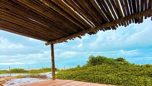 A wooden deck with a view of the sea and greenery. - Aponem Spa Pousada (Prado)