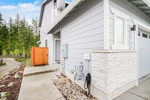 A residential building with a garage, a wooden shed, and a utility meter on the side. - Cozy Private 1BR Suite w/Trails and Amazing Views, Port Orchard (Port Orchard)