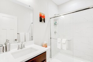 A modern bathroom with a large mirror, two sinks, a shower, and a toilet. - Cozy Private 1BR Suite w/Trails and Amazing Views, Port Orchard (Port Orchard)