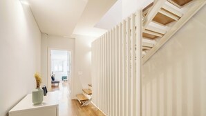 A modern interior with a staircase, wooden flooring, and a minimalist design. - Bellu Studios & Suites   (Braga)
