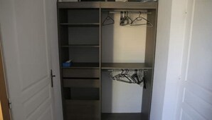 En rymlig klädkammare med öppna hyllor och plats för att hänga kläder.